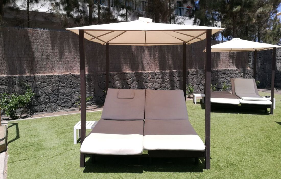 Fotografía de cama balinesa ecológica de plástico reciclado instalada en jardín de piscina
