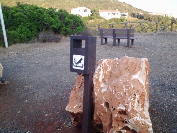 Detalle de cenicero ecológico de plástico reciclado instalado en zona de parque natural