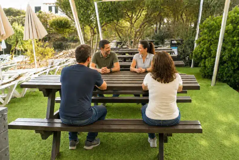 Detalle de mesa picnic ecológica de plástico reciclado usada por amigos