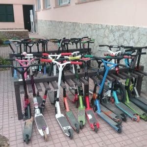 Detalle de aparca patinetes ecologico de plástico reciclado instalado en colegio y en uso