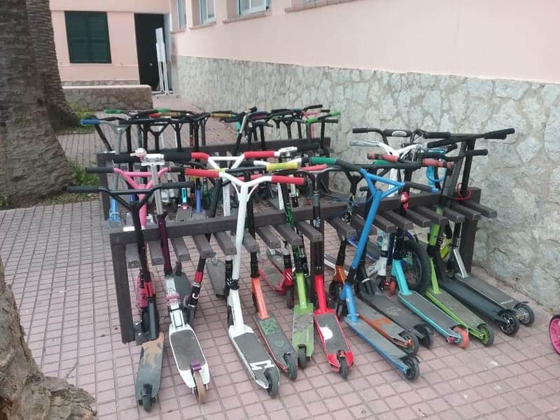 Detalle de aparca patinetes ecologico de plástico reciclado instalado en colegio y en uso