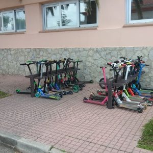 Detalle de aparca patinetes ecologico de plástico reciclado instalado en colegio y en uso