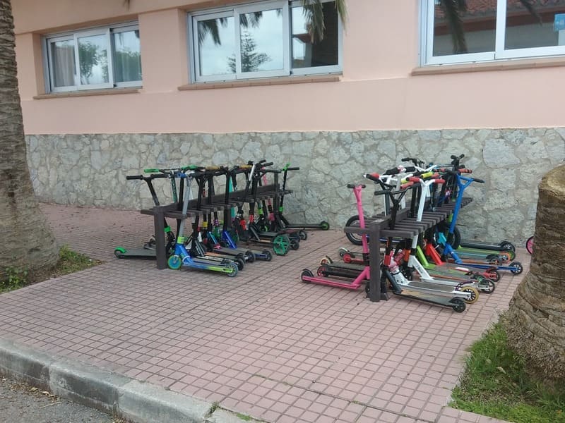 Detalle de aparca patinetes ecologico de plástico reciclado instalado en colegio y en uso