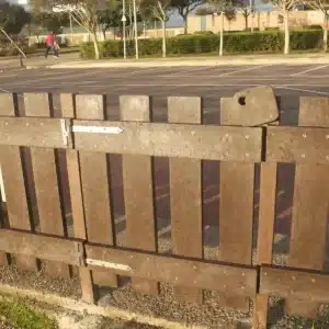 Detalle de cerca en zona ajardinada de puerta Vallado pipican de plástico reciclado